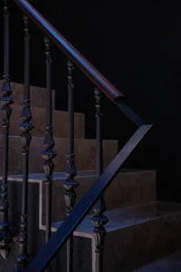 Industrial style staircase with black metal railings and wood steps.