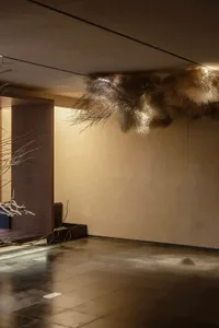 極簡空間中，帶有紋理的纖維從天花板垂掛