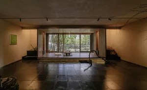 A minimalist yoga studio with wooden and plant materials in a serene setting.