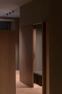 A modern bedroom featuring brown wooden furniture and minimalist design.