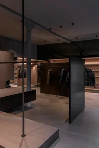 A modern retail store interior with dark walls and illuminated shelves.