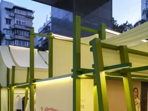 A modern shop interior with green wooden structures and white fabric elements.