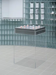 Transparent glass cubes arranged on a metallic base in a modern installation setting.