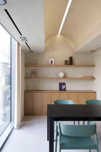 A modern restaurant dining room featuring wooden furniture, ambient lighting, and decorative items.