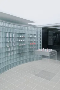 A modern storefront with glass walls and shelves.