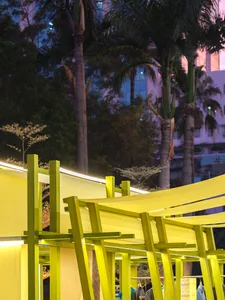 Modern storefront featuring bright yellow fabric and wooden beams.