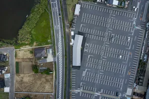 Aerial view of a modern parking lot with asphalt surface and clear demarcations.