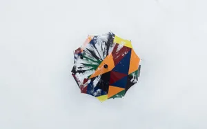 A colorful and abstract-patterned umbrella on a white surface