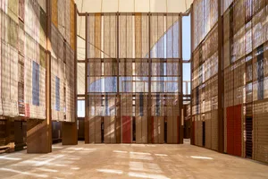 Large-scale installation of fabric dividers creating a layered, textured architectural space.