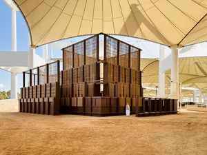 A modern indoor space featuring wooden structures and a fabric roof.