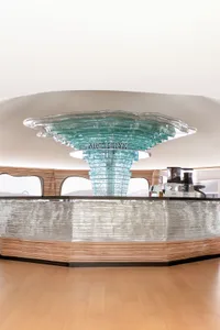 A modern coffee shop counter featuring a glass design with a glass top and stand.
