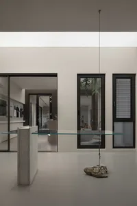 A modern interior featuring glass, concrete, and metal elements.