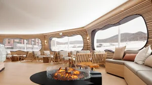 A modern lounge interior featuring a warm and inviting atmosphere with a wood-paneled room, cozy seating, and a central fire