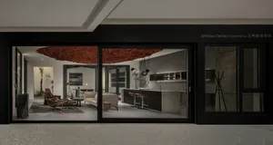 A modern residential space featuring a concrete kitchen and lounge area.