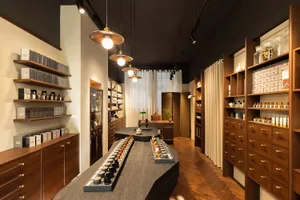 Modern retail store interior featuring a wooden perfume counter with various products displayed.