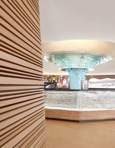 A modern retail shop with a glass column and wooden slat walls.
