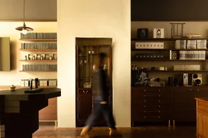 A modern retail storefront featuring a wooden and leather bar counter with glass display cases and shelves.