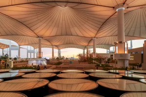 Modern public space featuring a textured textile roof, designed for open-air events or gatherings.