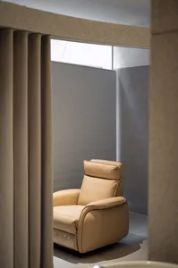 Modern living room featuring a beige leather recliner chair, with a bluish-grey textured wall and a frosted glass partition.