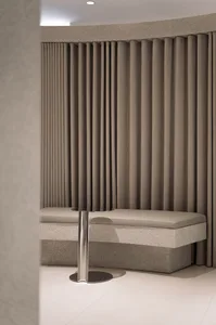 Modern waiting room with fabric seating, marble base, and metal table.