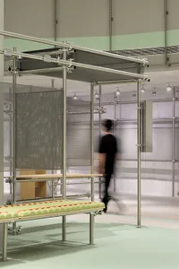 An industrial-style interior space featuring metal columns and mesh screens.