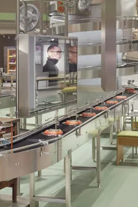 Metal conveyor system with orange tubes in a manufacturing environment