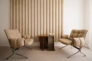 A modern living room with textured fabric furniture and a minimalistic table in the background.