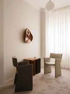 A contemporary living room featuring minimalist furniture and textured fabric upholstery.
