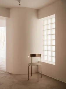 A minimalist metal chair in a modern interior design setting.
