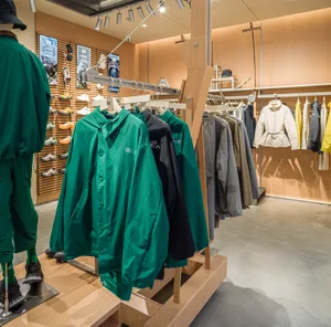 具有現代設計的零售店，陳列服裝架與鞋子展示區。