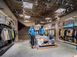 Modern retail store interior featuring clothing racks, mannequins, and shoes on display.