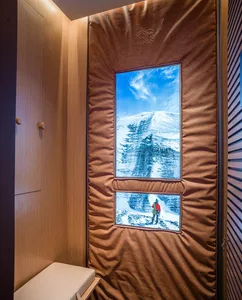 An interior space featuring a digital display of a snow-capped mountain viewed from within a room.