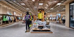 A retail store showcasing sportswear and accessories, with mannequins dressed in outdoor gear, and shelves filled with clothi