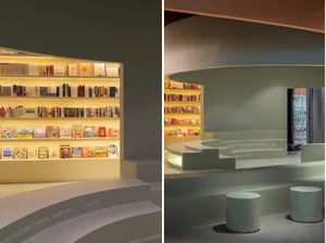 A photograph of a modern library interior featuring a concrete shelf with illuminated books.