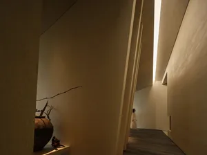 A minimalist corridor with wooden walls and a light source at the end.