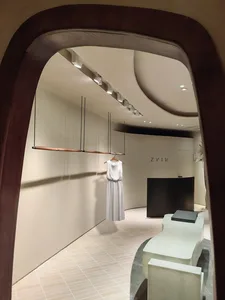 A minimalist retail store interior with wood accents, concrete walls, and glass elements.