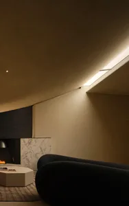 Modern living room featuring concrete and marble surfaces with LED lighting