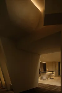 Interior view of a modern, minimalist residential space featuring a concrete floor and minimalist lighting.