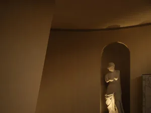 A modern marble sculpture installation displayed in a dimly lit interior space.