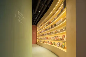 Modern bookstore with yellow lighting and bookshelves.