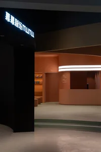 A modern lobby with orange and black walls and a reception counter.