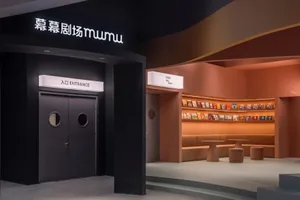 Modern theater entrance with black curved walls and white lighting.
