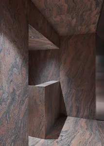A modern architectural space features tall bronze columns with a swirling design.