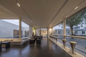 Modern industrial commercial space featuring concrete flooring and large windows.
