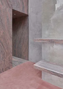 Modern interior design featuring textured granite walls and a smooth concrete floor.