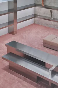 A modern interior featuring metallic furniture on a pink carpet.