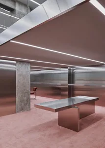 A minimalist office space featuring a metallic desk.