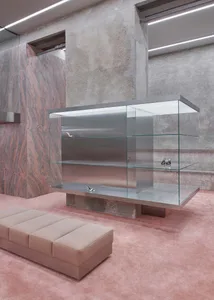 A modern retail storefront featuring a combination of marble, concrete, and glass materials.