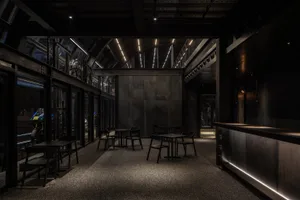 Industrial-style coffee shop with metal counters and black furniture.