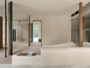 A minimalist living space featuring concrete walls and furniture.